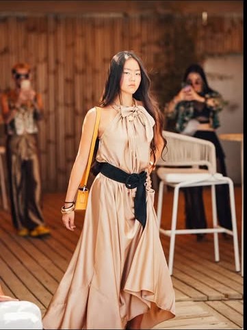 Mannequin en robe longue beige lors d'un défilé